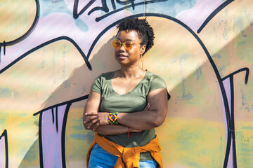 portrait of black woman with arms crossed on wall