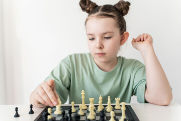 Little girl playing chess, focused look. Selected Focus