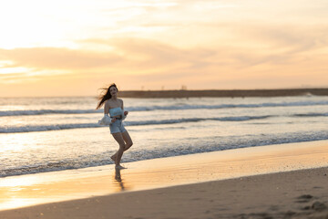 A woman is running on the beach at sunset