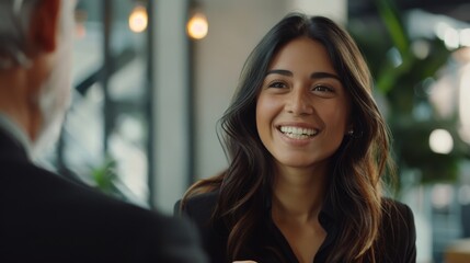 Latina businesswoman in a streamlined office setting, enthusiastic, initiating handshake with senior male client, warmth and achievement in her smile, styled as soft-focus realism.
