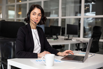 Happy smiling female customer support phone operator at workplace - 793700502