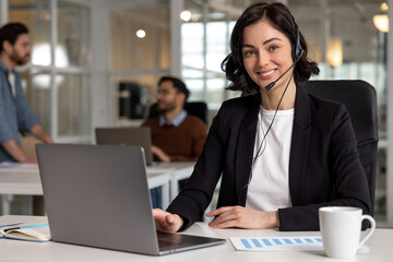 Young friendly operator woman agent with headsets working in call center in contemporary office - obrazy, fototapety, plakaty