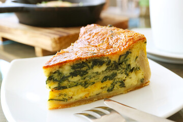 Slice of Delectable Spinach Quiche on a White Plate