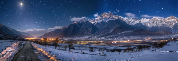 night view of  snow covered mountains in winter and stars shining brightly above them with city light in distance
