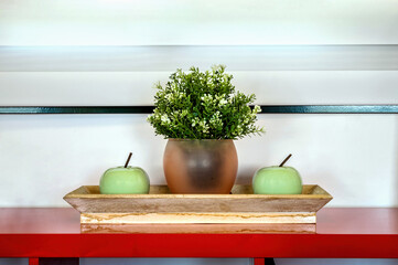 Captivating close-up of a wooden tray featuring a vibrant green plant nestled in a flower pot at...
