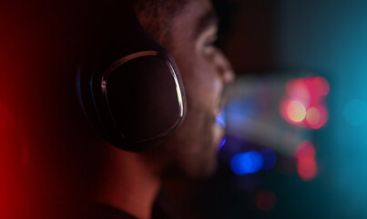 Gaming, headphones and man in esports at night in competition with online video games. Gamer, nerd...