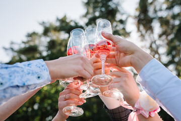 Cheers. People celebrate wedding and raise glasses of wine for toast in the backyard. Group of men...