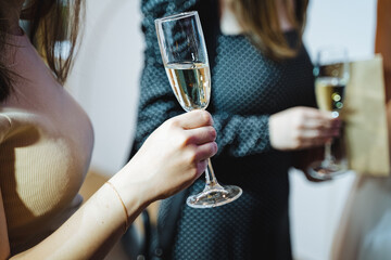 A woman with outerwear holding a glass of champagne in her hand