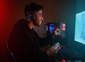 Pro gamer, man and cheers for winning with fist, goals and success in global rpg contest on web. Person, winner and excited with celebration, challenge or competition with computer in home at night