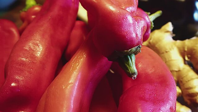 Close up of red bell peppers. sweet peppers and ginger roots. Kitchen interior. Bell peppers are wet with droplets of water. Indoor studio shot. . High quality 4k footage