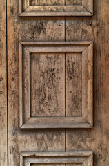 part of an old wooden entrance door in front with decorative frames - 793728738