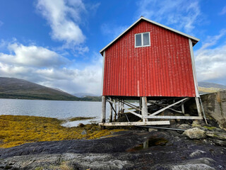 old typical red hut on stilts at the edge on the sea in Sweden scandinavia