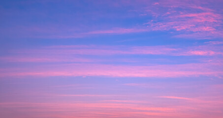 Colorful evening sky background with thin clouds streak on beautiful romantic pastel pink and blue...