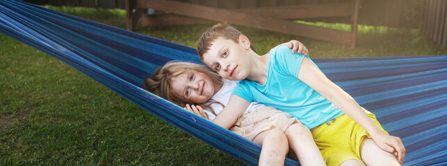 children brother and sister resting in the garden on a hammock