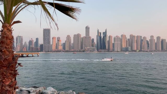 Dubai Jumeirah beach with marina skyscrapers in UAE. Luxurious sandy beach. Boat