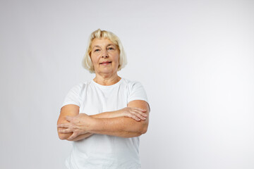 Beautiful senior blonde 60s woman smiling and looking at camera over white background. Human...