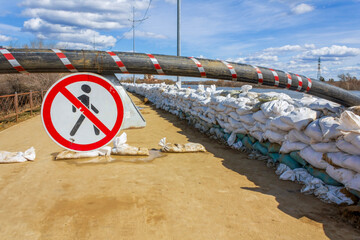 The stop sign near the wall of white sandbags, which has been erected as a barricade for flood protection  in the city of Kurgan, Russia.