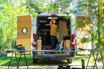 Man installing a skylight on his camper van