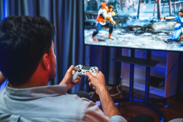 Focusing photo of holding joystick with fighting gaming competition of video game on blurred...