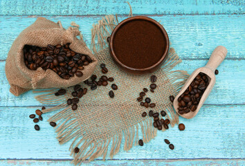  Kaffeebohnen auf türkisfarbenem Holzhintergrund.	