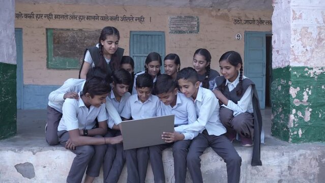 Group of Rural indian school students using laptop, Young boys and girls Learn computer technology at elementary school. Smart Kids, Knowledge, Digital India.