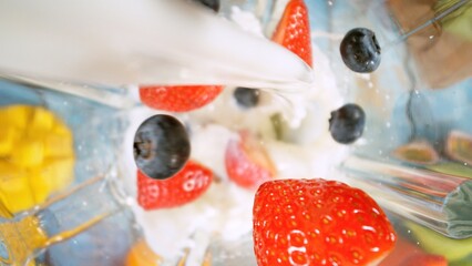 Overhead Shot of Pieces of Fruits with Milk in Blender.