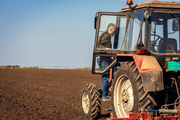 Farmer enters the tractor in the agricultural field.
