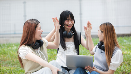 Group Of Young Asian Students Collaborating Outdoors at University. Teamwork and Knowledge Sharing. Asian Students Engaged in Collaborative Learning Outdoors.