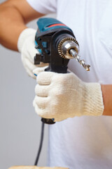 Man holding drilling tools in whtie gloves