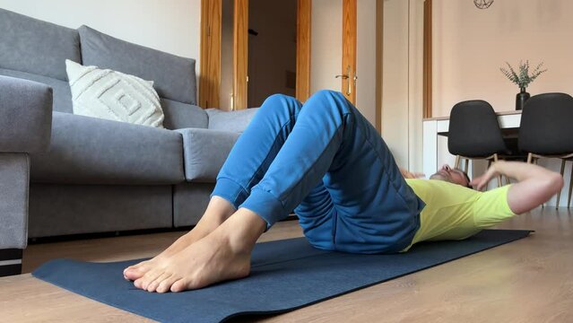 Home Ab Workout: 40-Year-Old Man Prioritizing Fitness. Dedicated 40-year-old man strives to stay active in limited spare time, focusing on ab exercises at home.