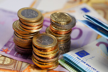 Stacked euro coins and banknotes close up photo with narrow depth of field