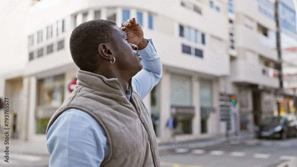 Sticker African man in casual attire looking intently while standing on a city street