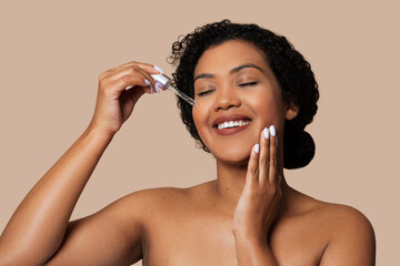 Smiling Woman Applying Facial Serum for Skincare Routine