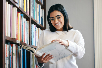 Young, female student and book from library on campus to prepare with research or information for...