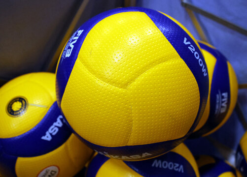 Gelb-blaue Mikasa-V200W-Volleyb&auml;lle liegen in einem Ballkorb. Hallenvolleyb&auml;lle f&uuml;r Training und Wettkampf in der deutschen Volleyball Bundesliga.