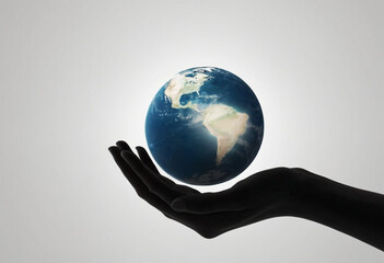 A silhouette of a hand holding a small, detailed globe representing the Earth. The bright, white background contrasts with the dark silhouette of the hand.