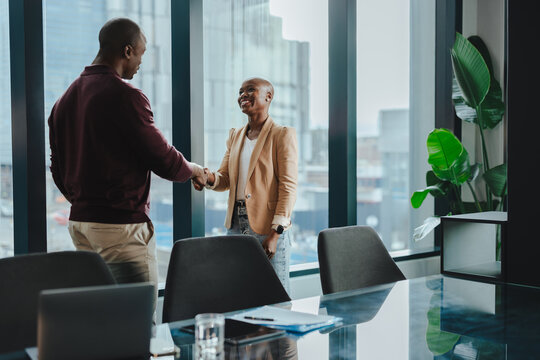 Successful business partners shaking hands in a corporate office