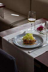 Cold Pork and Beans Salad with Escarole at Restaurant Table - Fine Dining Food and Drink in Elegant Setting