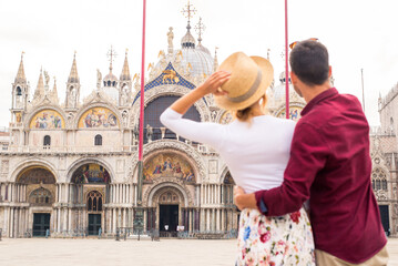 Happy young couple traveling in Venice, Italy - Cheerful tourists visiting venetian landmarks on a...