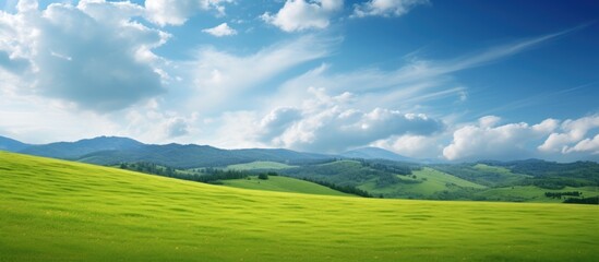 Green field, majestic mountains, cloudy sky
