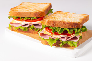 Club sandwich with ham, cheese, tomato and lettuce. 