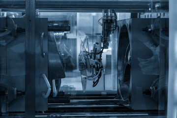 The plastic electric fan parts from  injection machine  gripped by  vacuum robotic system. - Powered by Adobe