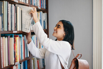 Knowledge, woman and student in library, searching and school with education, excited and studying. Happy person, college and girl with novel, literature and bookshelf with scholarship and university