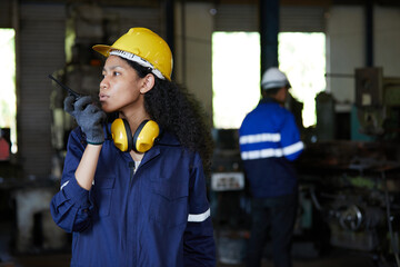 factory worker or engineer talking on walkie talkie in the factory