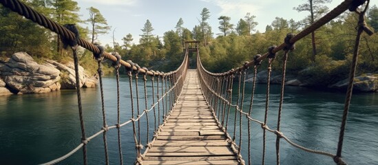 Suspension bridge above stream in lush woodland