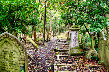 schmaler Weg  durch alte Grabsteine auf dem Highgate Cemetery in London Camden