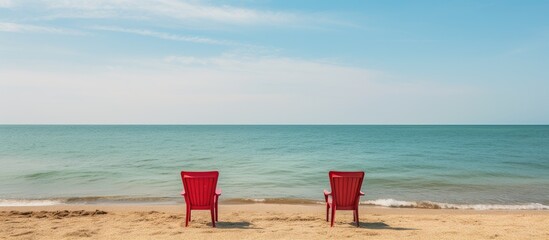 Two chairs on a beach by the sea - obrazy, fototapety, plakaty