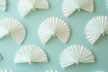 Group of White Paper Fans Arranged on Blue Background with Light Blue Sky, Minimalist Design Concept