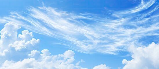 Plane flying in clear blue sky with fluffy clouds