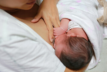 Mother feed her baby son with breast milk.